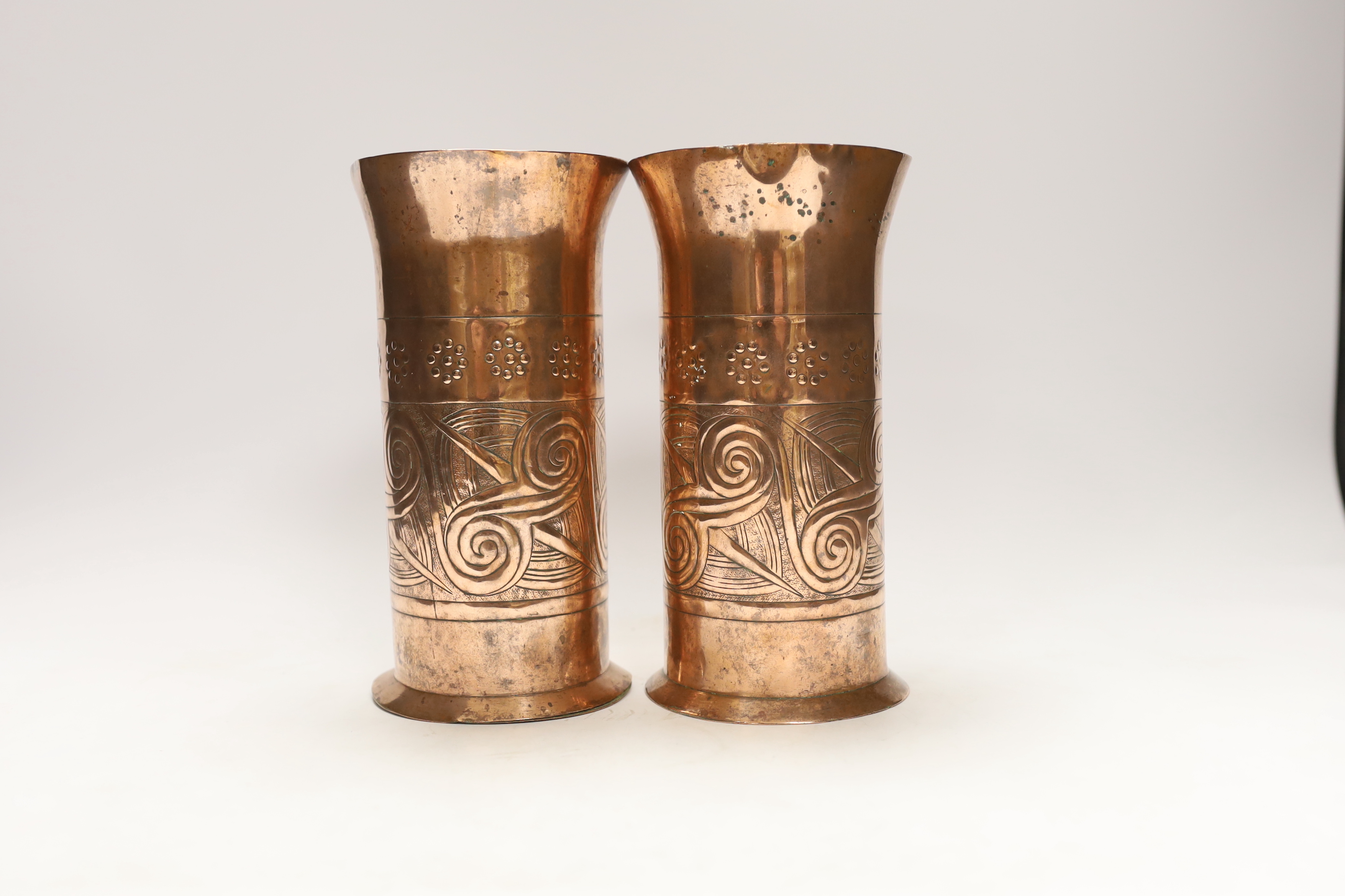 A pair of Keswick School of industrial art embossed copper cylinder vases, stamped KSIA to the bases, 20cm high